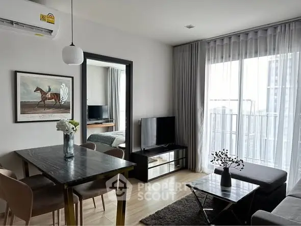 Modern living room with dining area and balcony view, featuring sleek furniture and natural light.