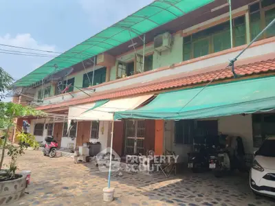 Charming residential building with spacious outdoor area and covered parking, ideal for family living.