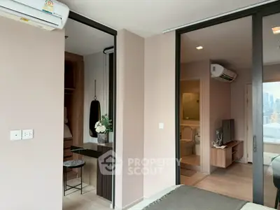 Modern bedroom with ensuite bathroom and city view, featuring sleek design and air conditioning.