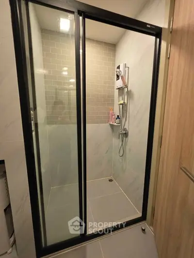 Modern bathroom with sleek glass shower enclosure and stylish tile design.