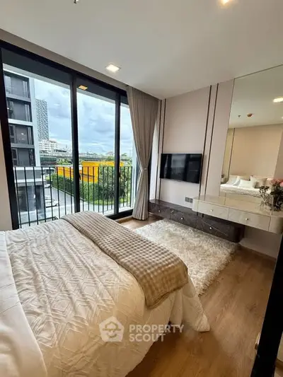 Modern bedroom with large windows and city view, featuring cozy decor and elegant furnishings.
