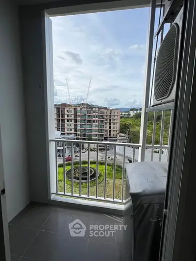 Charming balcony view overlooking urban landscape with modern architecture and lush greenery.