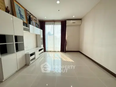 Spacious living room with modern white cabinetry and large window for natural light.