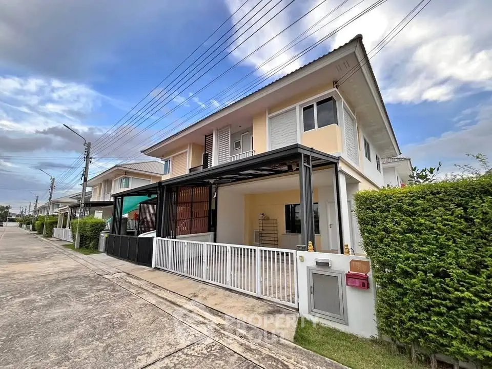 Modern two-story house with a sleek design and well-maintained garden in a suburban neighborhood.
