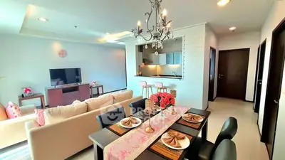 Spacious open-plan living and dining area with elegant chandelier and modern decor.