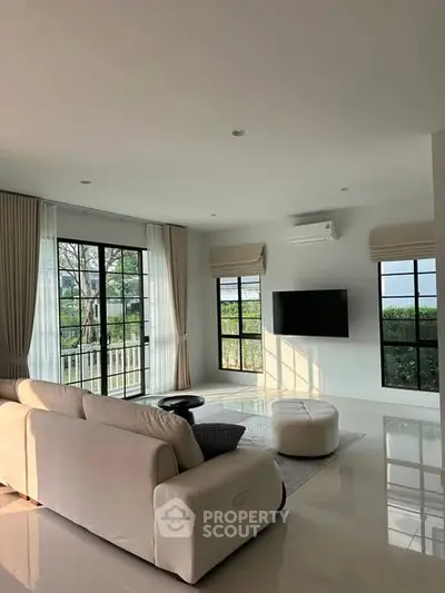 Spacious modern living room with large windows and elegant decor