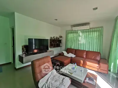 Modern living room with leather sofa, wall-mounted TV, and air conditioning, perfect for relaxation.