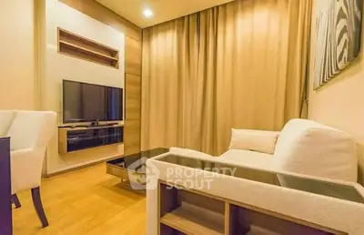 Modern living room with cozy seating and wall-mounted TV in stylish apartment.