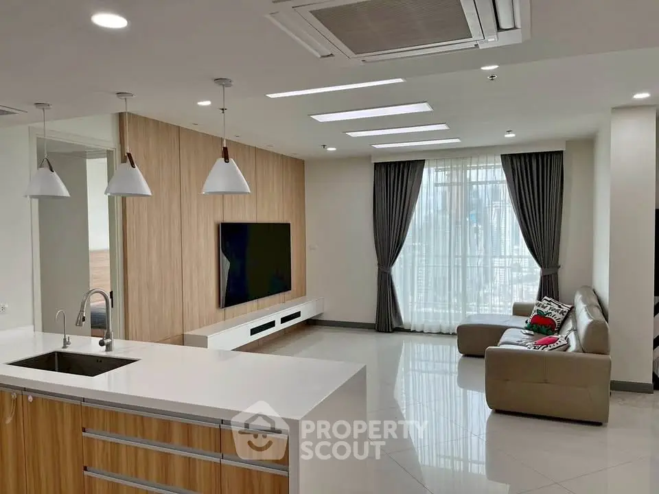 Modern open-plan living room with sleek kitchen and large windows