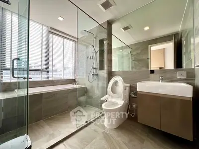 Luxurious modern bathroom with glass shower and bathtub in high-rise apartment.