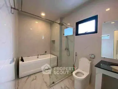 Modern bathroom with glass shower and bathtub in luxury home