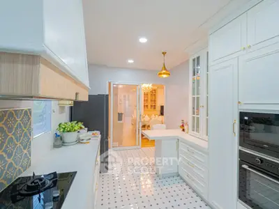 Spacious kitchen with modern appliances and elegant design, featuring a gas stove and ample storage space.