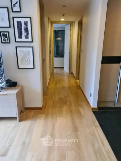 Modern apartment hallway with wooden flooring and stylish wall art