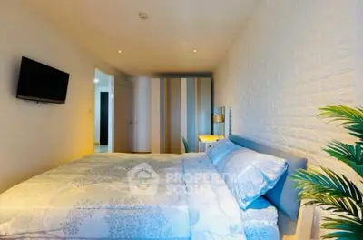 Modern bedroom with stylish decor and wall-mounted TV