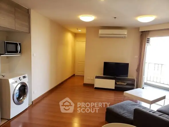 Modern living room with washing machine and balcony access in a stylish apartment.