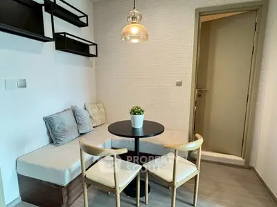Cozy dining nook with modern seating and pendant light in a stylish apartment.