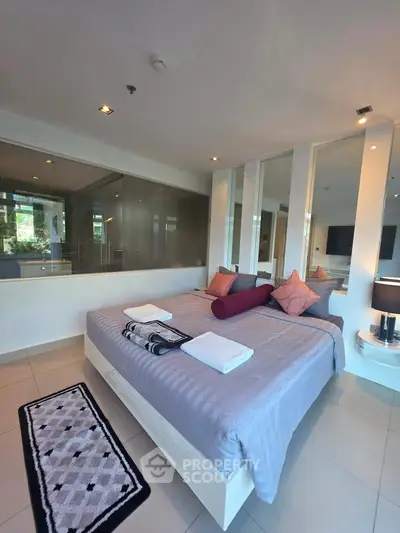 Luxurious modern bedroom with stylish decor and large windows offering natural light.