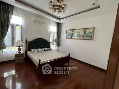 Spacious bedroom with elegant wooden flooring and stylish decor in a modern home.