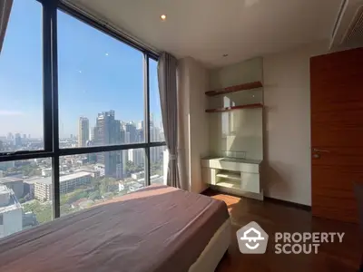 Spacious bedroom with large windows offering panoramic city views, modern design, and ample natural light.