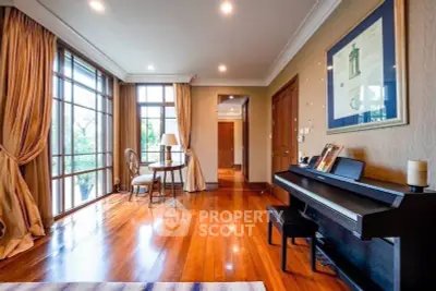 Elegant living room with piano, large windows, and wooden flooring.
