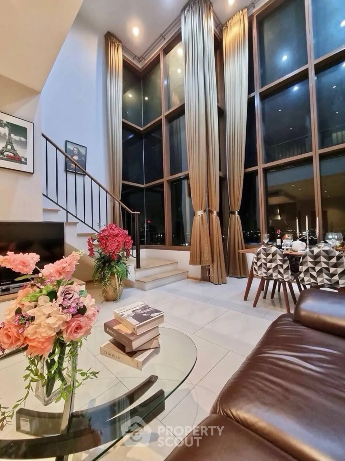 Luxurious living room with high ceilings, large windows, and elegant decor in a modern apartment.