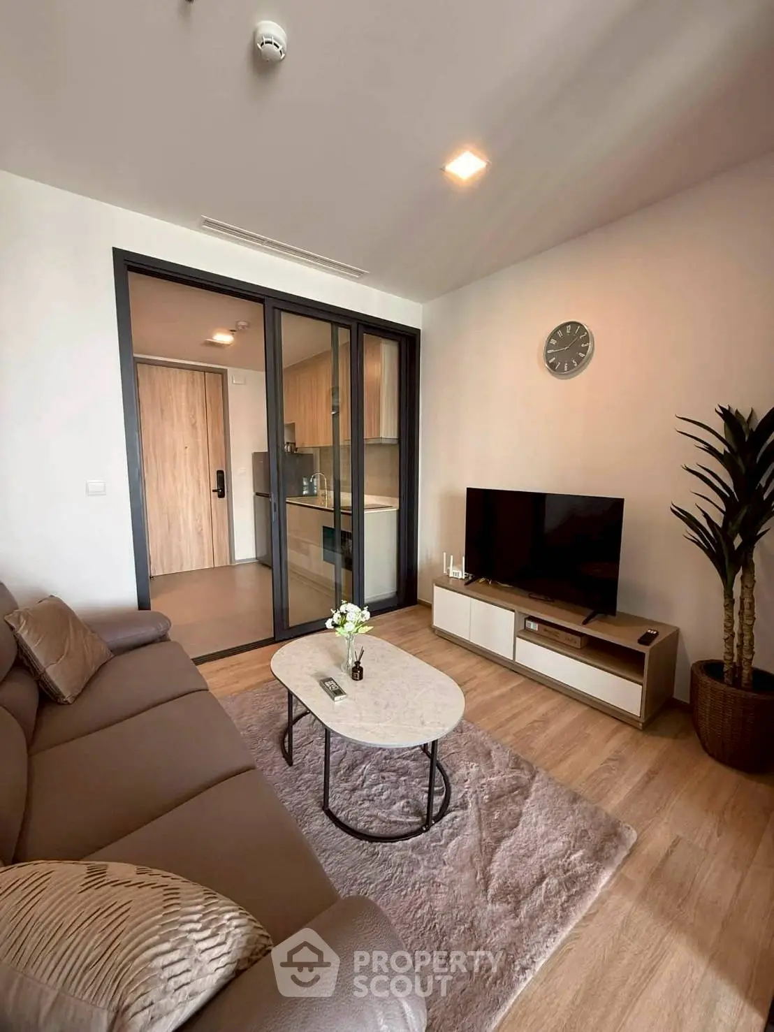 Modern living room with cozy sofa, stylish decor, and open kitchen layout in a contemporary apartment.