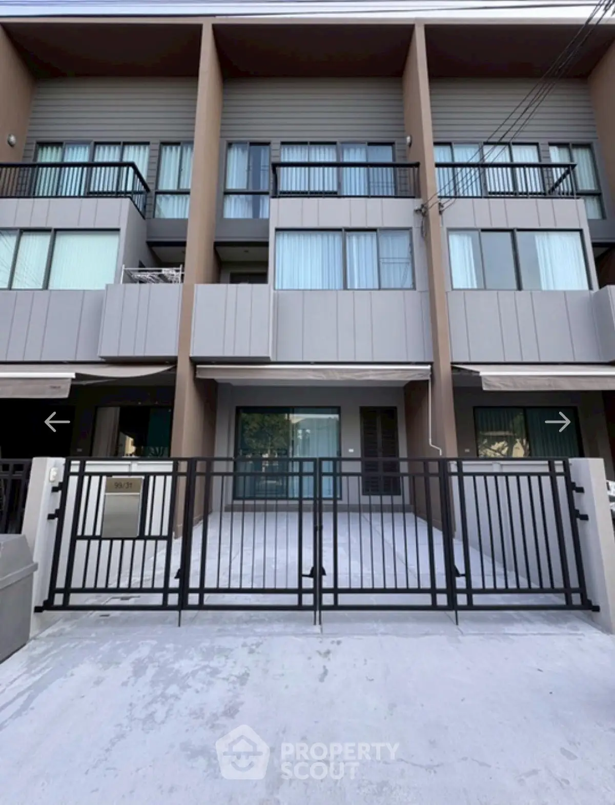 Modern townhouse exterior with sleek design and gated entrance, perfect for urban living.