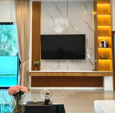 Luxurious living room with modern TV setup and pool view, featuring elegant decor and ambient lighting.