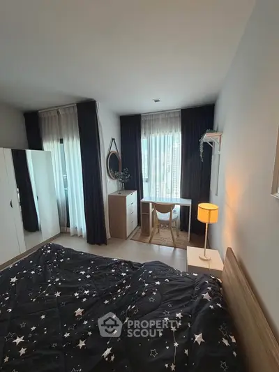 Cozy bedroom with stylish decor and natural light, featuring a study desk and modern furnishings.