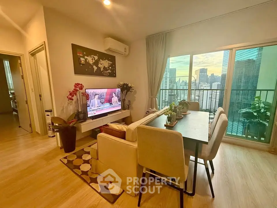 Modern living room with city view, featuring stylish decor and cozy seating area.