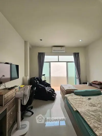 Spacious bedroom with modern amenities and natural light, featuring a comfortable bed and sleek furnishings.
