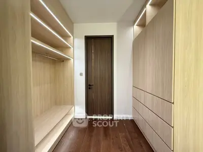 Spacious modern walk-in closet with wooden shelves and drawers.