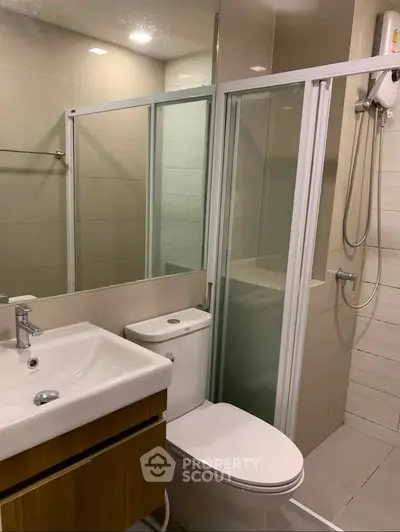 Modern bathroom with glass shower enclosure and sleek fixtures