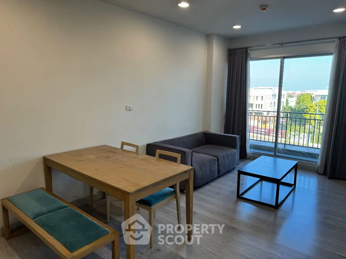 Modern living room with wooden dining set and balcony view