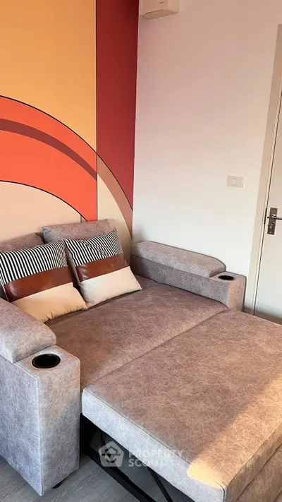 Modern living room with stylish sofa bed and vibrant wall art, perfect for urban living.