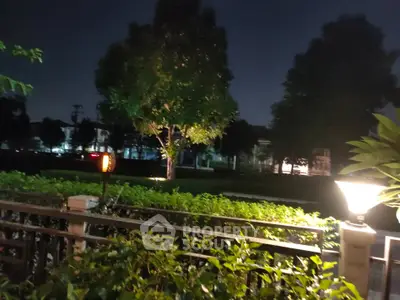 Serene night garden view with lush greenery and ambient lighting