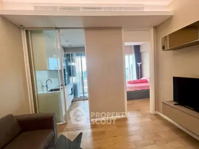 Modern apartment interior with open layout, featuring a cozy living area and a glimpse of the bedroom.