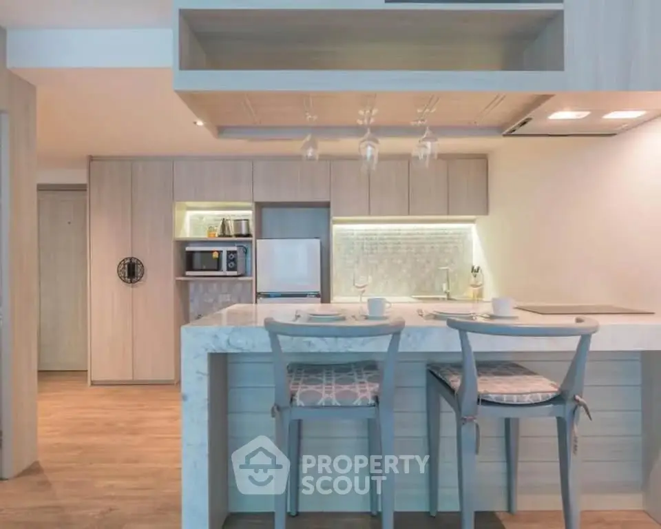 Modern kitchen with marble island and stylish bar stools in open layout