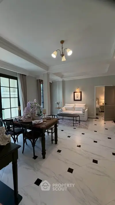Elegant living room with dining area, featuring modern decor and marble flooring.