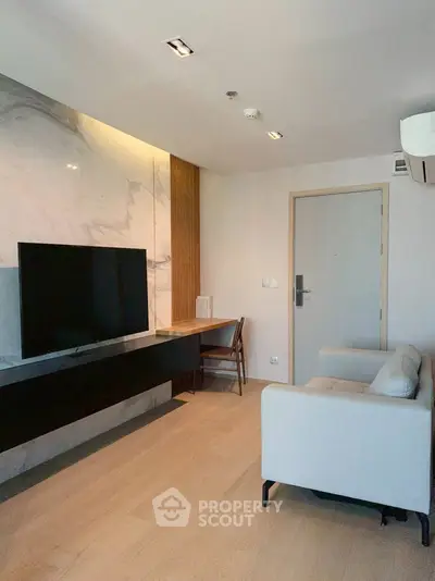 Modern living room with sleek TV setup and stylish marble wall accent.