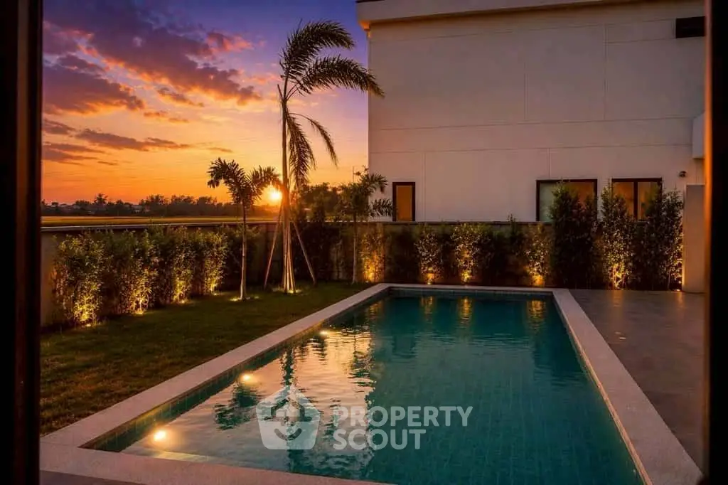 Luxurious private pool with stunning sunset view and lush garden landscaping.