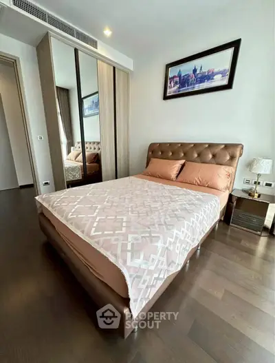 Modern bedroom with stylish decor and wooden flooring in a contemporary apartment.