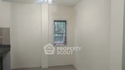 Minimalist interior with neutral walls and a small window, ideal for customization.