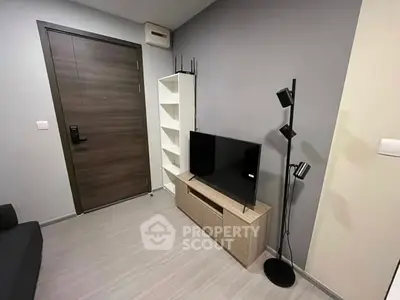 Modern living room with sleek TV setup and stylish floor lamp.