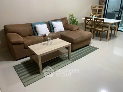 Cozy living room with brown sofa, coffee table, and dining area, perfect for relaxation and entertaining.