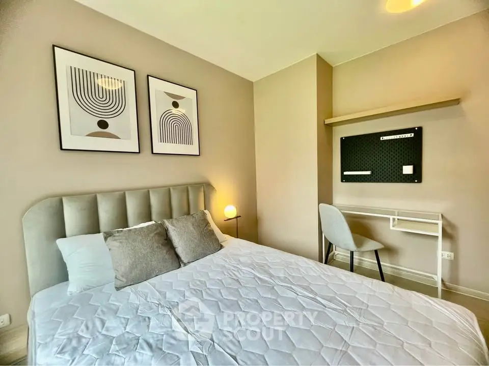 Modern bedroom with stylish decor and cozy ambiance, featuring a comfortable bed and sleek wall art.