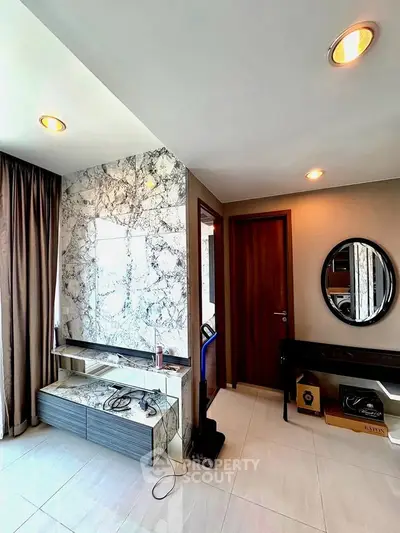 Modern interior with marble accent wall and sleek furniture in a stylish apartment.