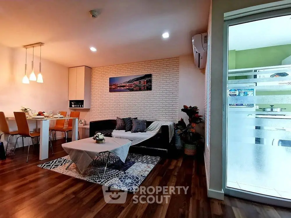 Modern living room with stylish decor and dining area, featuring wooden flooring and cozy lighting.