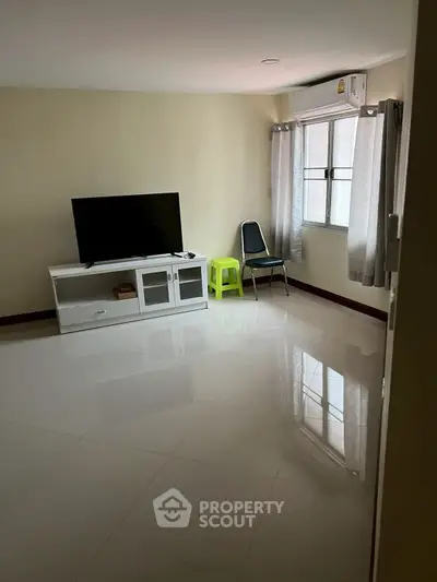 Spacious living room with modern TV setup and natural light