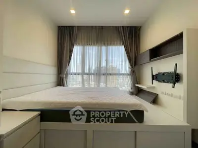 Modern bedroom with built-in storage and large window offering city views